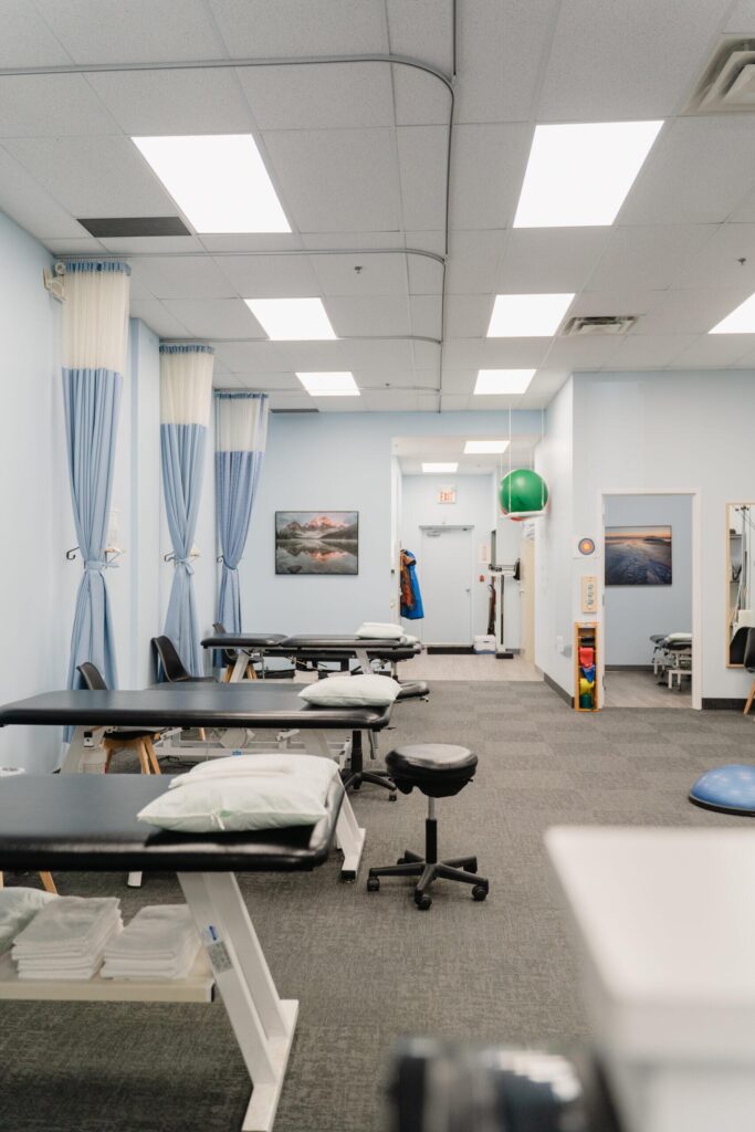 Treatment area at the Eramosa Physiotherapy Associates Acton clinic, with treatment tables, privacy curtains and an exercise ball